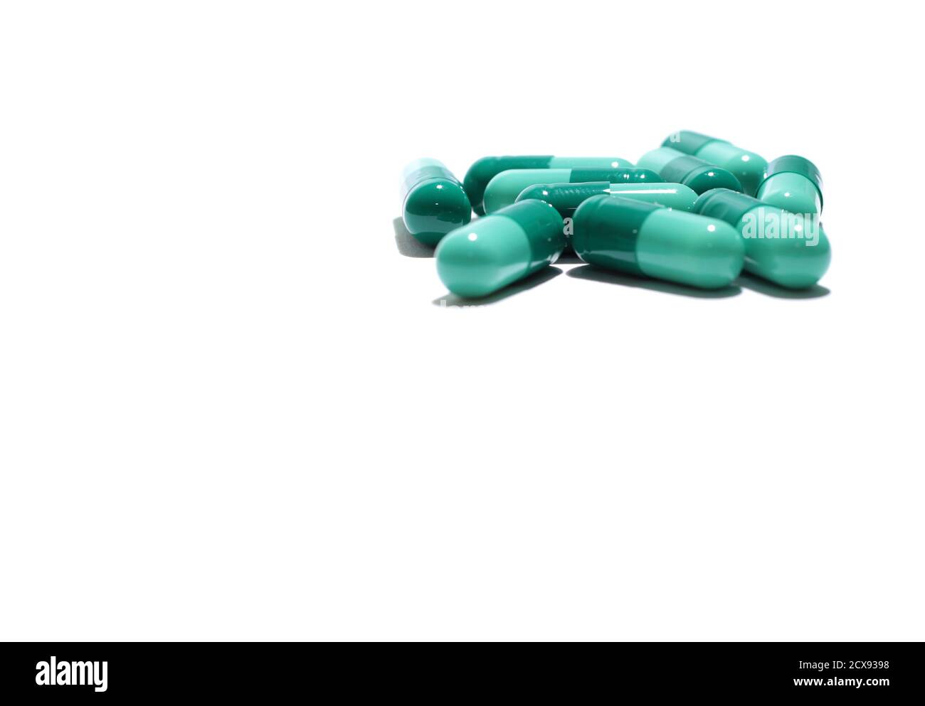 Medicine Pillen verschüttet aus einer Flasche auf einem farbigen Flaschenhintergrund. Stockfoto