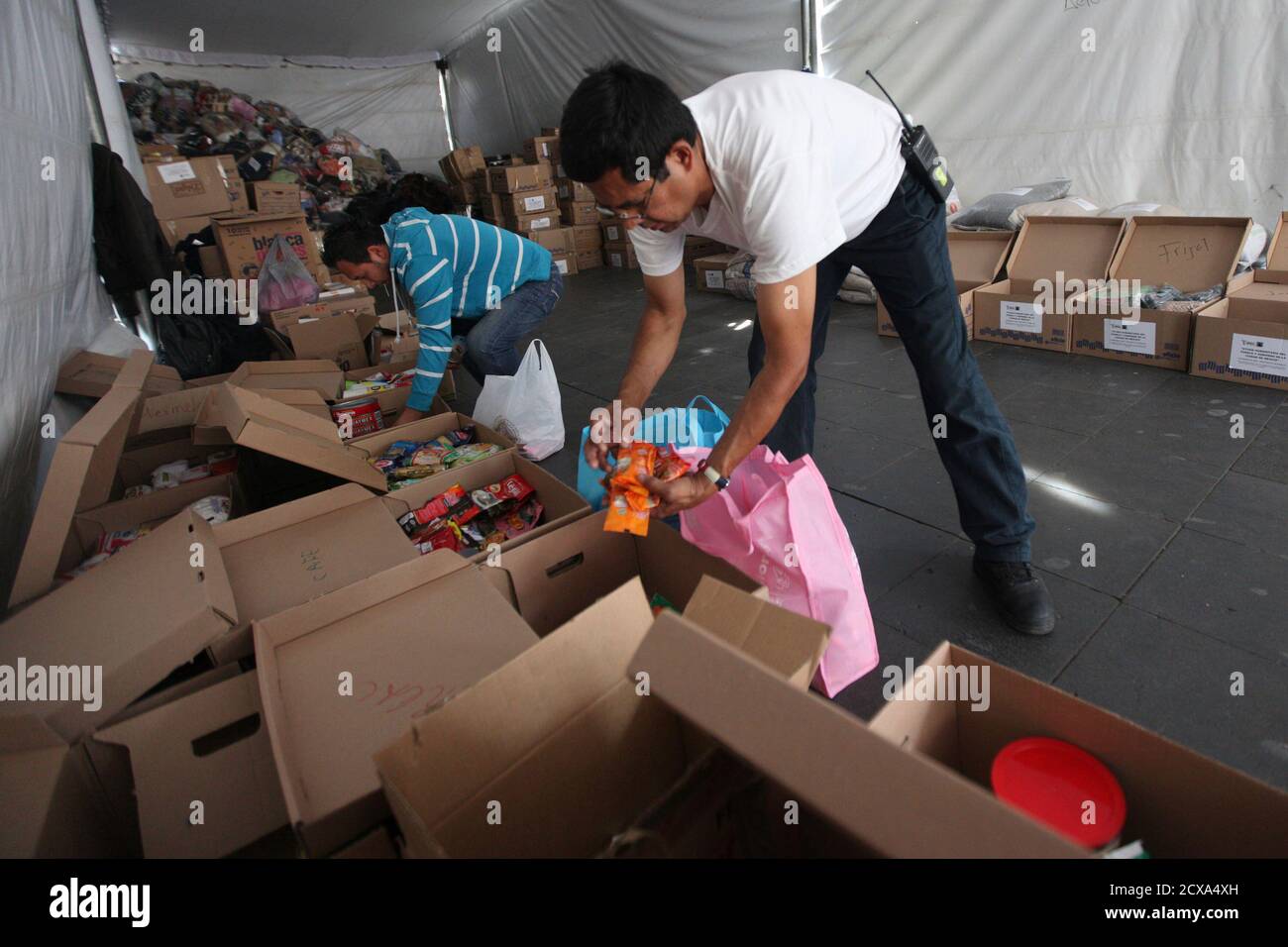Freiwillige sortieren Lebensmittel, die von mexikanischen Bürgern an  Tarahumara-Indianer am Zocalo-Platz in Mexiko-Stadt gespendet wurden, 20.  Januar 2012. Die Freiwilligen sammelten Nahrung, Medikamente, Decken und  andere Hilfsgüter, um der indischen ...