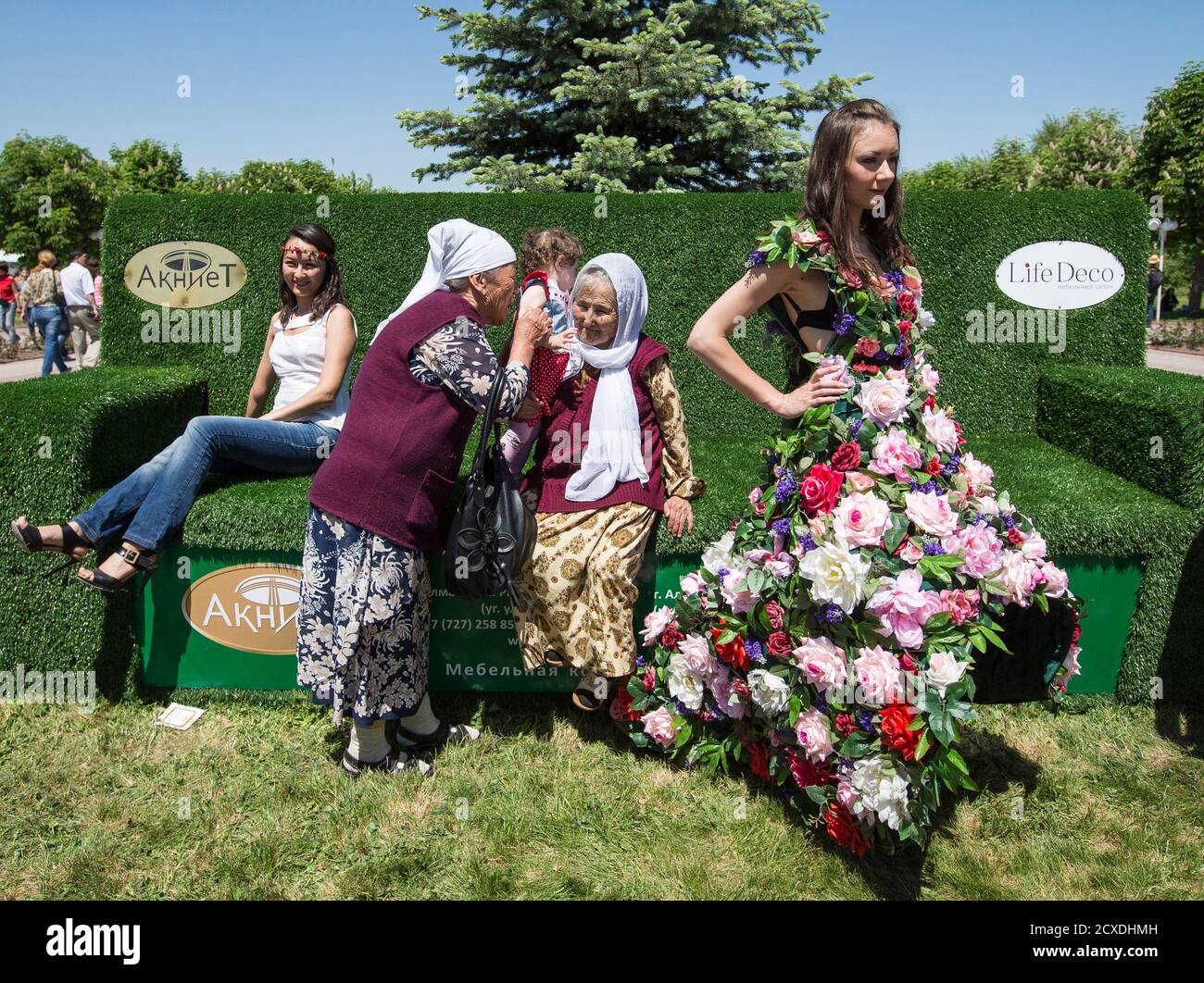 Ein Modell mit einem Outfit gemacht von Blumen (R) Posen wie Zuschauer ein Blumenfest in Almaty 24. Mai 2014 besuchen.  REUTERS/Schamil Zhumatov (Kasachstan - Tags: Gesellschaft) Stockfoto