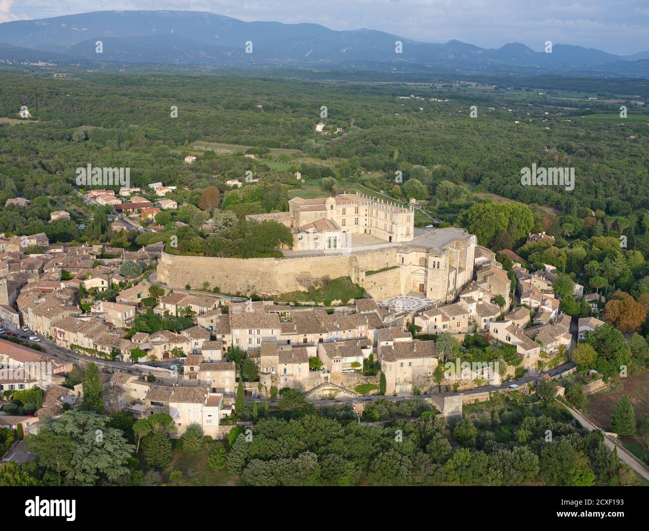 LUFTAUFNAHME. Mittelalterliche Burg auf einem felsigen Hügel, mit Blick auf das alte Dorf gebaut. Schloss Grignan, Drome, Auvergne-Rhône-Alpes, Frankreich. Stockfoto