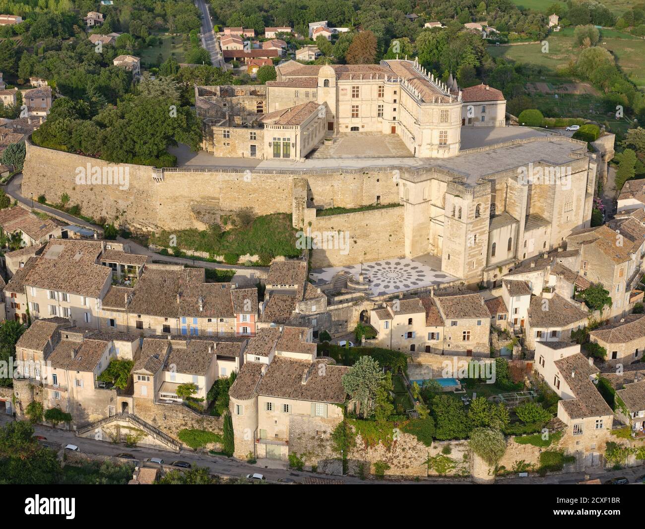 LUFTAUFNAHME. Mittelalterliche Burg auf einem felsigen Hügel, mit Blick auf das alte Dorf gebaut. Schloss Grignan, Drome, Auvergne-Rhône-Alpes, Frankreich. Stockfoto