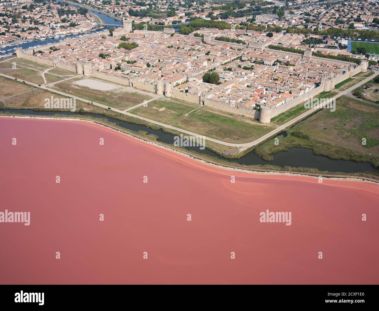 LUFTAUFNAHME. Die mittelalterliche ummauerte Stadt Aigues-Mortes mit Marais de Peccais (einem Salzverdampfungsteich) im Vordergrund. Gard, Österreich, Frankreich. Stockfoto