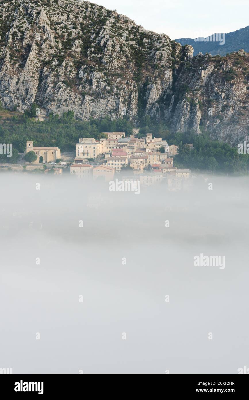 Das mittelalterliche Dorf Saint-Auban liegt oberhalb des tief liegenden Morgennebels. Alpes-Maritimes, Frankreich. Stockfoto