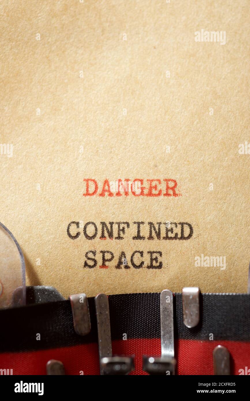 Mit Schreibmaschine geschriebener Ausdruck „Gefahr in engen Räumen“. Stockfoto