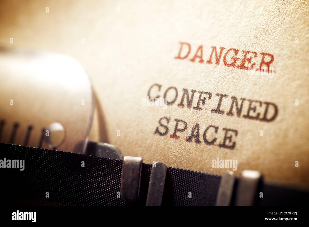 Mit Schreibmaschine geschriebener Ausdruck „Gefahr in engen Räumen“. Stockfoto