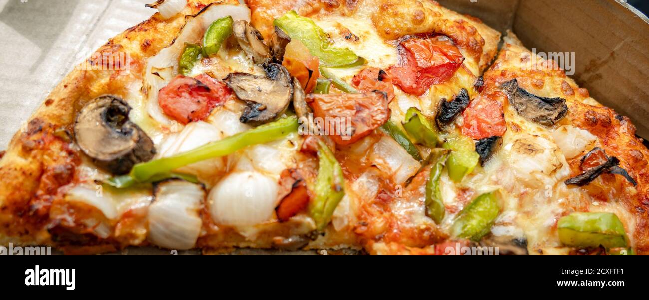 Nahaufnahme einer handgezuckenen Pilzpizza mit Pilzen, Zwiebeln, knusprigen grünen Paprika oder Paprika, jalapeños und frischen Tomaten Stockfoto