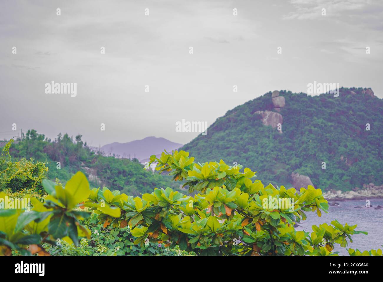 Zeitänderungskonzept. Schönheit Panorama Landschaft Landschaft Felsen bewaldete Küste Berg in der Ferne Hintergrund düster grau nebligen Himmel nach Regen Abend Stockfoto