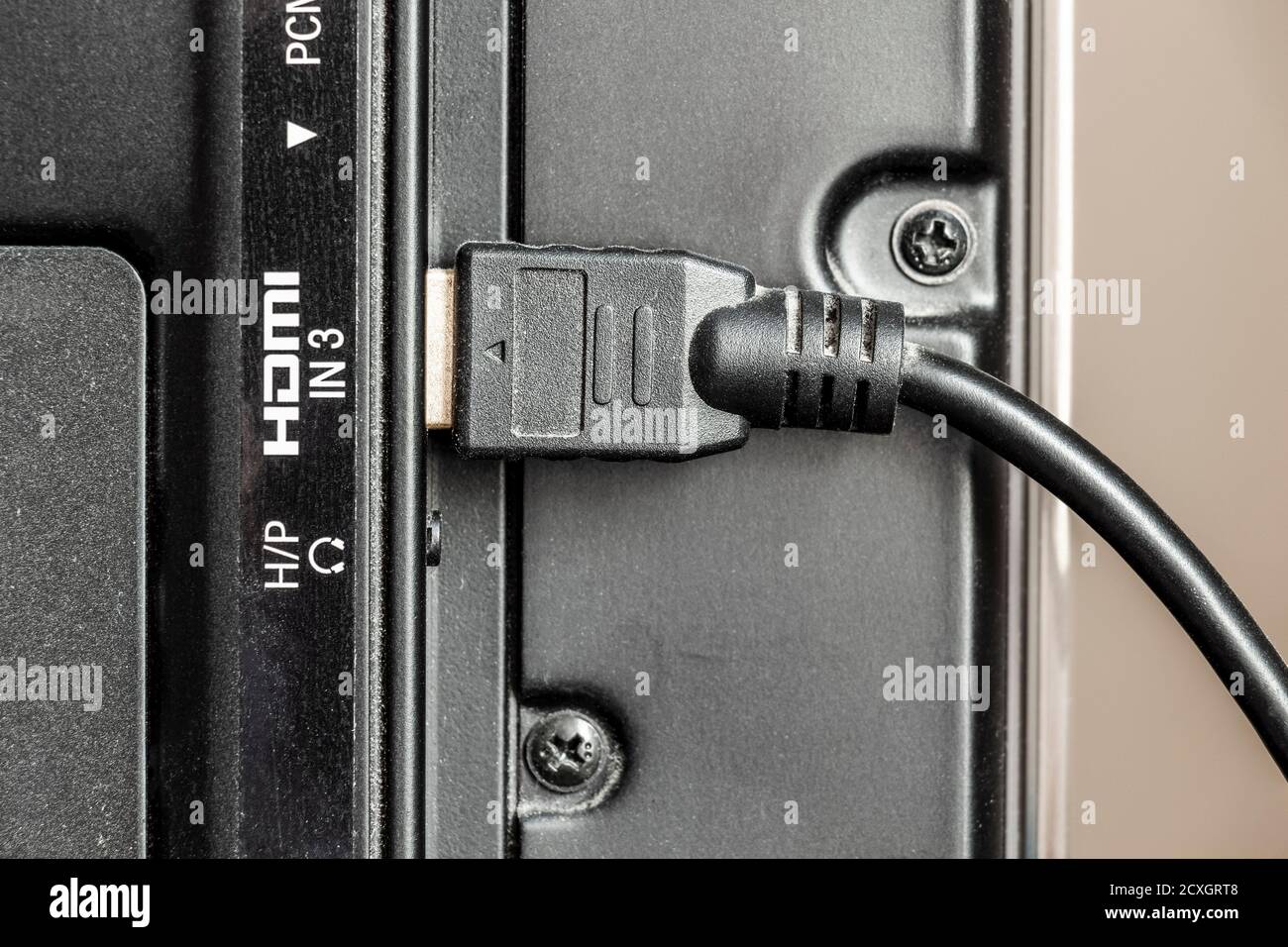 Das HDMI-Kabel ist an die TV-Buchse angeschlossen. Stockfoto