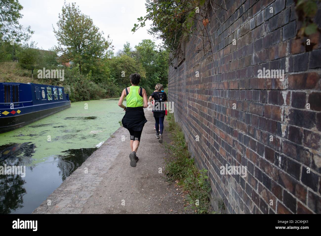 Die Damen joggen neben dem Chesterfield Canal auf einem trüben und bewölkten Septembertag Stockfoto