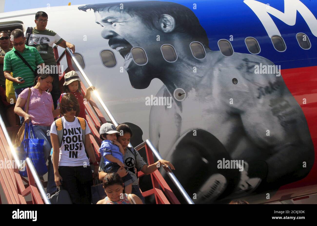 Passagiere steigen aus dem AirAsia Philippines Airbus A320, der mit dem Bild der philippinischen Boxerin Manny Pacquiao verputzt ist, als sie von Cebu am Inlandsflughafen in Pasay City, Metro Manila Apiril 28, 2015 ankommen. AirAsia Philippinen zeigen ihre Unterstützung für Pacquiao, indem sie ihr Flugzeug mit dem Namen und Gesicht der Box-Ikone bemalen, sagte ein AirAsia-Beamter. Pacquiao wird am 2. Mai in Las Vegas, Nevada gegen den amerikanischen Boxer Floyd Mayweather Jr. antreten. REUTERS/Romeo Ranoco Stockfoto
