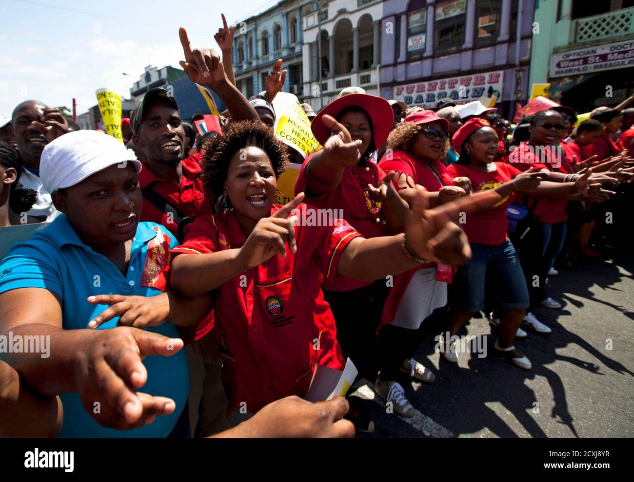 Streikende Mitglieder des Congresses of South African Trade Unions (COSATU) marschieren am 7. März 2012 durch das Stadtzentrum von Durban. Zehntausende Südafrikaner haben am Mittwoch einen eintägigen Nationalstreik durchgeführt und die Bergbauproduktion getroffen, als die größte Arbeitergruppe in der größten Volkswirtschaft des Kontinents ihre Muskeln beugte, um den regierenden Afrikanischen Nationalkongress (ANC) an seine politische Stärke zu erinnern. Die unmittelbaren Ziele des Streiks sind neue Straßenmaut in Johannesburg und kurzfristige Arbeitsagenturen, von denen COSATU sagt, dass sie Arbeitnehmer ausbeuten und die Ungleichheiten des Apars der weißen Minderheit aufrechterhalten Stockfoto
