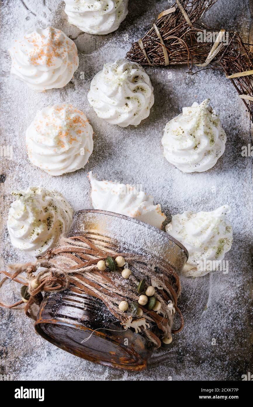 Hausgemachte weiße französische Baiser als Weihnachtstanne verziert von Farbiger Zucker und Matcha Tee aus Geschenkdose über Pulverförmige alte Metall Hintergrund wi Stockfoto