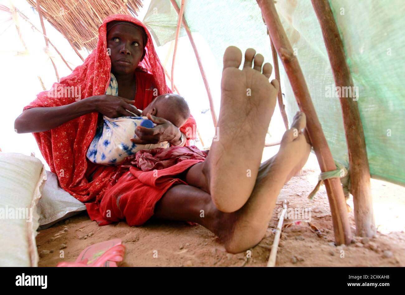 Eine Vertriebene Frau füttert ihr Kind innerhalb ihrer provisorischen Schutz-Struktur im Qansahaley Siedlung Camp in der Dollow Stadt entlang der Grenze zu Somalia und Äthiopien, 30. August 2011. Einige 3,7 Millionen Somalier von Hunger in die schlimmste Dürre in Jahrzehnten bedroht sind und die meisten von denen sind aus fünf Bereichen im Rebellen kontrollierten Süden wo Hungersnot erklärt worden ist.  REUTERS/Thomas Mukoya (SOMALIA - Tags: Katastrophe Gesellschaft Armut TPX Bilder des Tages) Stockfoto