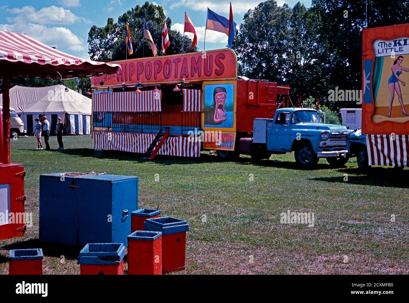 Ein Vintage-Foto der Nebenschauplatz-Gasse am Clyde Beatty Cole Bros Brothers Combined Circus, USA um 1960. Die Attraktion ist Big Otto, der lebende Hippopotamus. Das bemalte Werbematerial wird jetzt als Volkskunst betrachtet. Dieses Bild ist von einem alten amerikanischen Amateur Kodak Farbtransparenz. Stockfoto