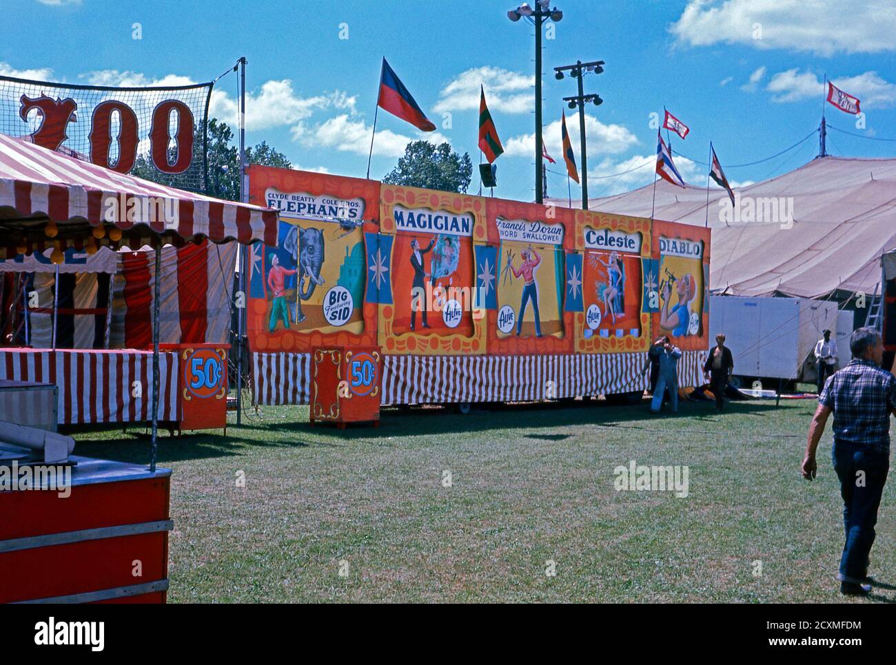 Ein Vintage-Foto der Nebenschauplatz-Gasse am Clyde Beatty Cole Bros Brothers Combined Circus, USA um 1960. Die handbemalten Banner zeigen, dass die Attraktionen Elefanten, ein Zauberer, Frances Doran (ein Schwert Swallower), Celeste und Diablo (wahrscheinlich ein Feuer Esser) gehören. Das bemalte Werbematerial gilt heute als Volkskunst. Dieses Bild ist von einem alten amerikanischen Amateur Kodak Farbtransparenz. Stockfoto