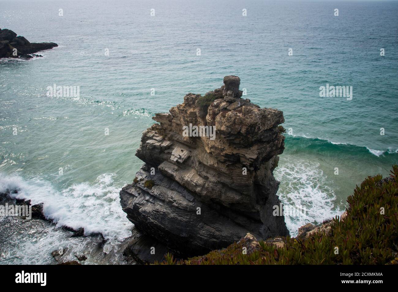 Große graue Felsformation steht an der Meeresküste in der Nähe Klippen am Strand Stockfoto