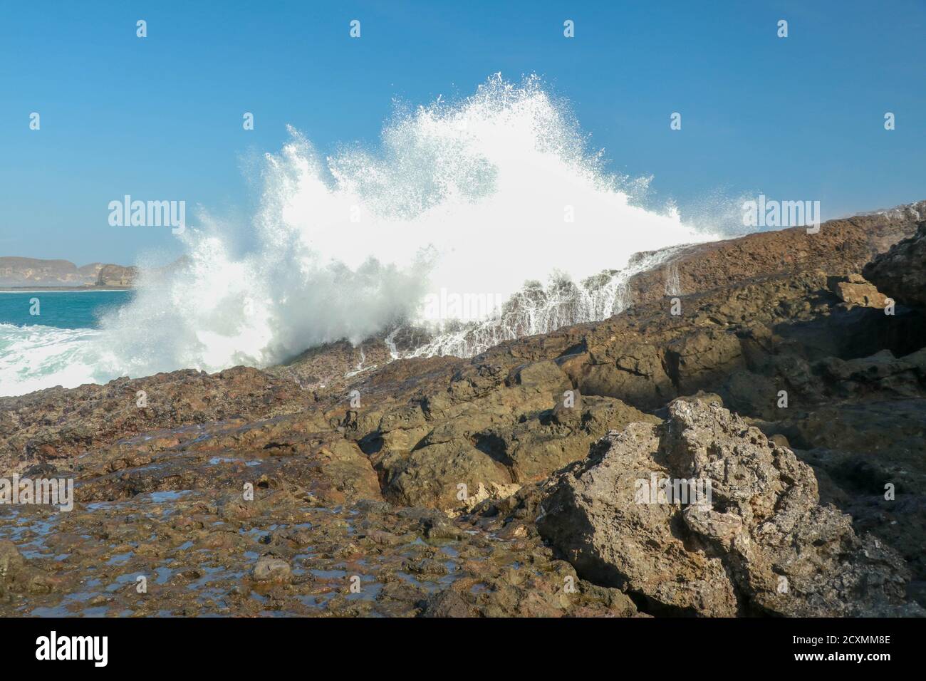 Wellen planschen auf einer Landzunge rund um den Strand von Tanjung Aan. Gefährliches Phänomen an einem himmlischen Strand. Wasser wird durch die Stärke der Zerkleinerung sprudelt Stockfoto