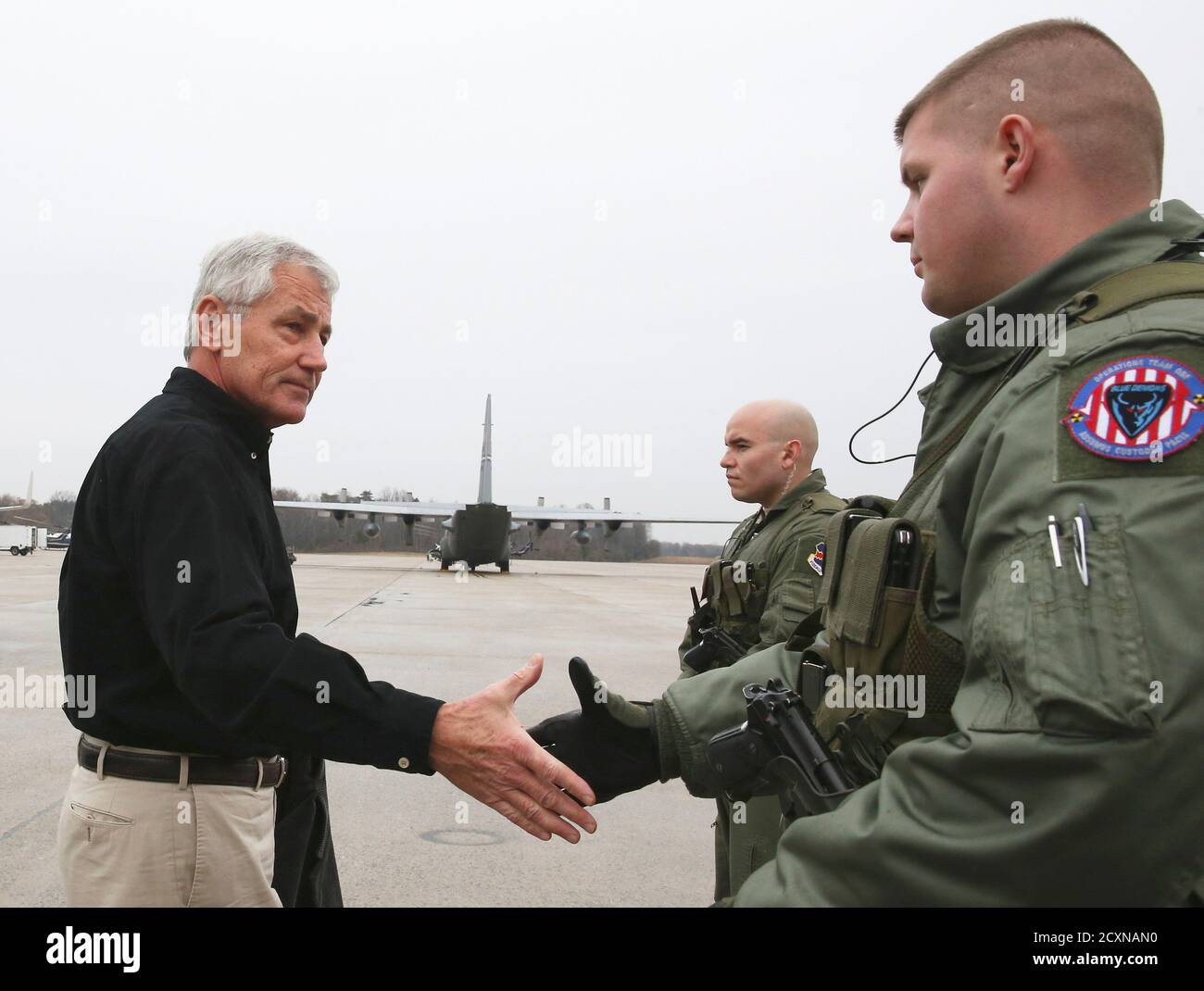 US-Verteidigungsminister Chuck Hagel (L) begrüßt zwei Mitglieder von der US Air Force vor seinem Flugzeug, Abfahrt auf einer Auslandsreise in gemeinsame Basis Andrews, Maryland am 5. Dezember 2014. REUTERS/Mark Wilson/Pool (Vereinigte Staaten - Tags: militärische) Stockfoto