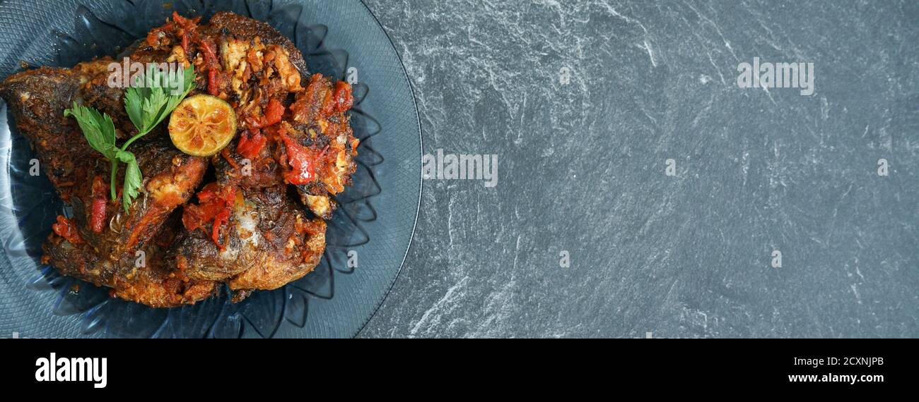 Hausgemachter gebratener Papageienfisch mit Chili ist asiatische kulinarische Gerichte, die auf einem Steinblock serviert werden Stockfoto