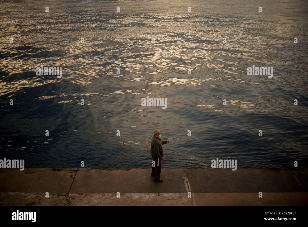 Barcelona, Spanien. 1. Oktober 2020, Barcelona, Katalonien, Spanien: Am frühen Morgen hält ein Mann mit einer schützenden Gesichtsmaske ein Seil und versucht, in einem Wellenbrecher von Barcelona einen Oktopus aus dem Meer zu fangen. Quelle:Jordi Boixareu/Alamy Live News Stockfoto