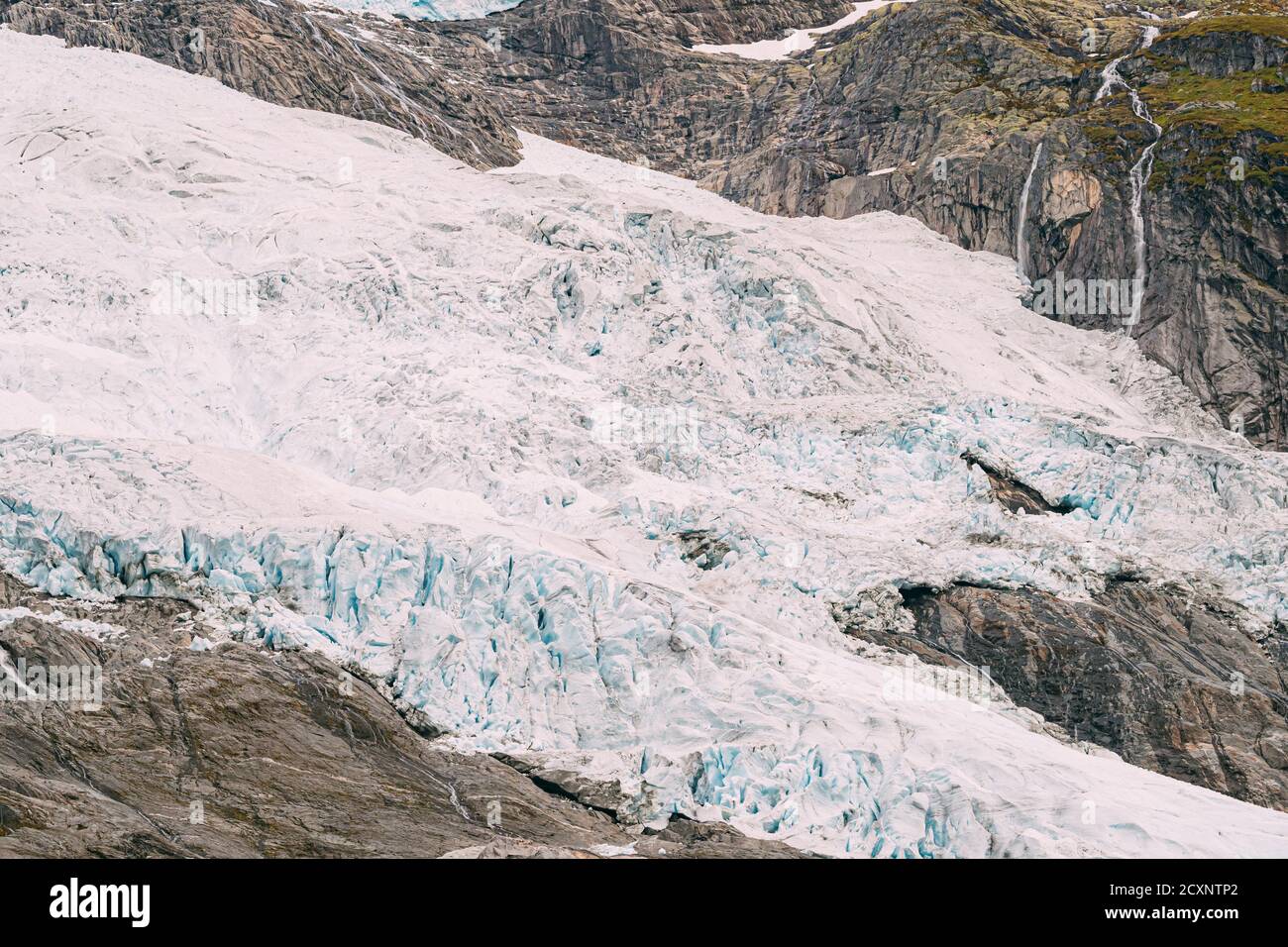 Jostedalsbreen Nationalpark, Norwegen. Nahaufnahme Blick Auf Schmelzendes Eis Und Schnee, Kleiner Wasserfall Auf Dem Boyabreen-Gletscher Im Frühling Sonnentag. Berühmt Stockfoto