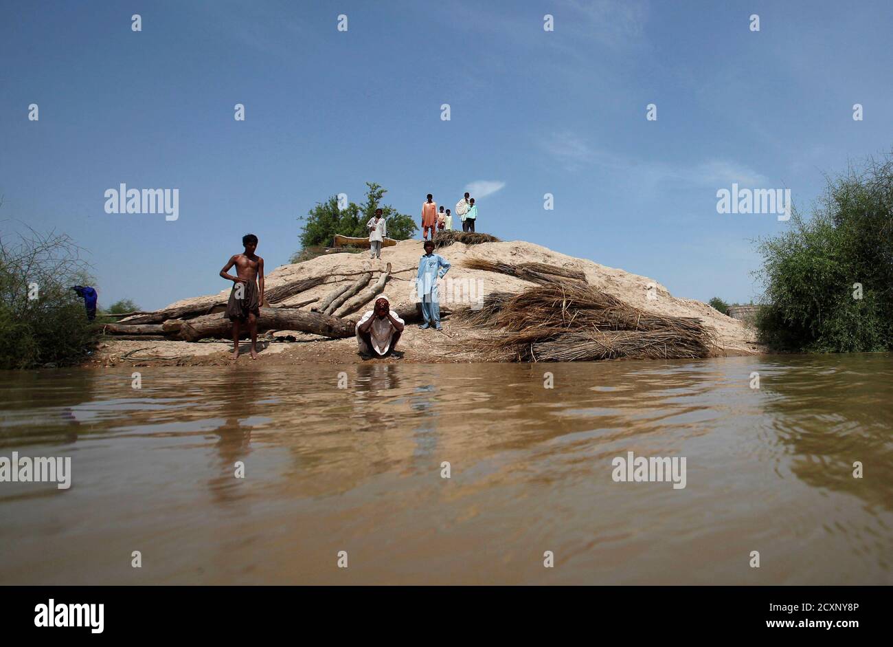 Achar, ein Opfer der Flut, führt Waschung vor dem Gebet während der Einnahme Zuflucht auf einem Hügel mit anderen in Amri Dorf, etwa 280 km (174 Meilen) von Karatschi auf 19. August 2010. Mehr als 4 Millionen Pakistaner von fast drei Wochen von Überschwemmungen obdachlos vorgenommen wurden, sagte der Vereinten Nationen am Donnerstag, die kritische Aufgabe größere Mengen von dringender Hilfe zu sichern. REUTERS/Akhtar Soomro (PAKISTAN - Tags: DISASTER-Umgebung) Stockfoto