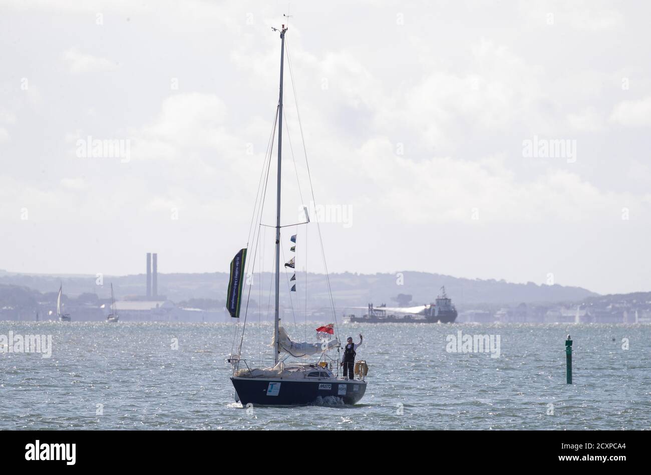 Der 15-jährige Timothy Long winkt dem Ufer entgegen, als er sein 28-Fuß-Boot "Alchemy" in Hamble Point Marina, Hampshire segelt und der jüngste Mensch wird, der alleine durch Großbritannien segelt. Stockfoto