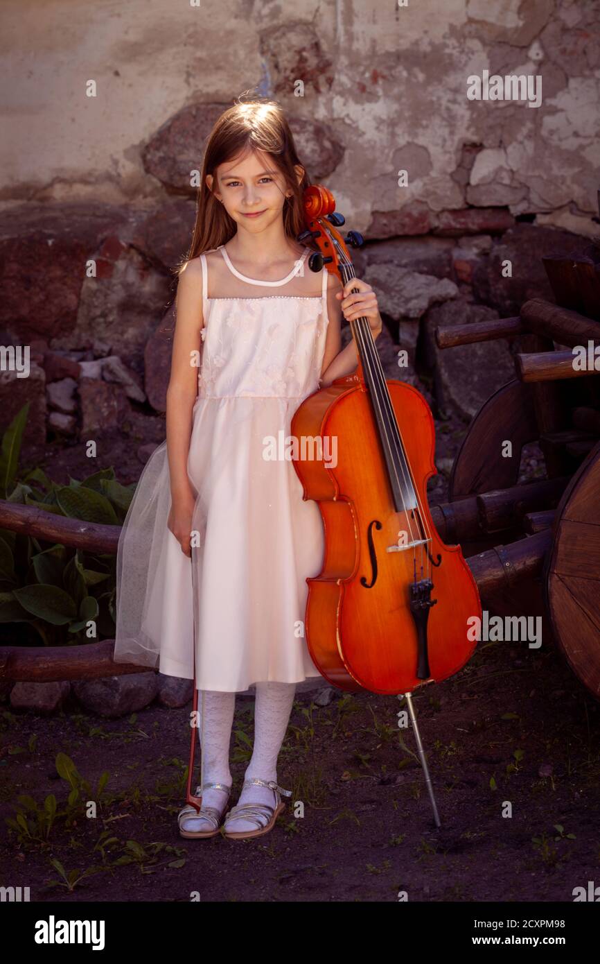 Schönes Mädchen in einem rosa Kleid mit einem Cello Stockfoto