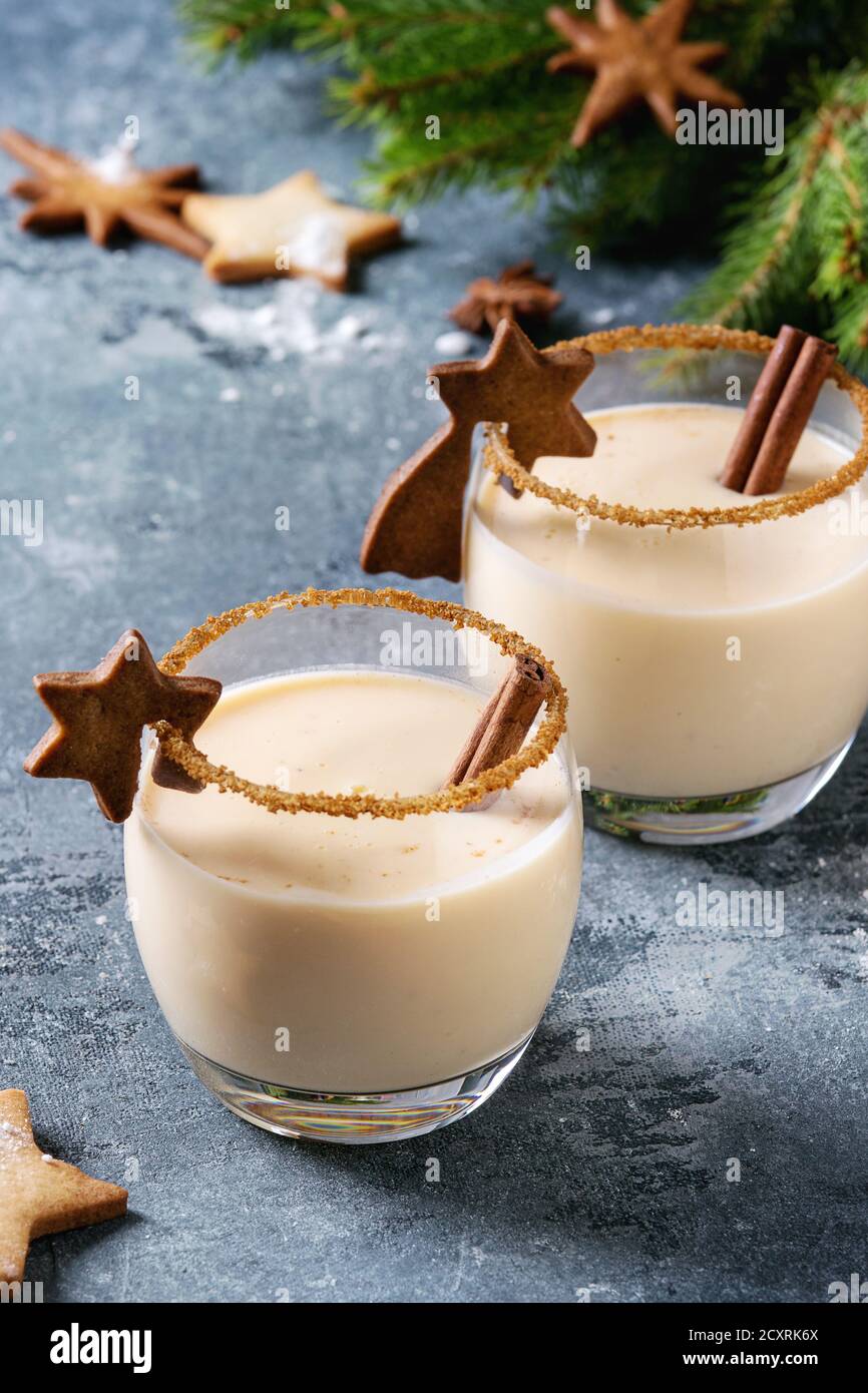 Eierkuchen Weihnachten Milch Cocktail mit Zimt, serviert in zwei Gläsern mit Shortbread Stern Form Zucker Kekse in verschiedenen Größen, Dekor Spielzeug, Tannenzweig ov Stockfoto