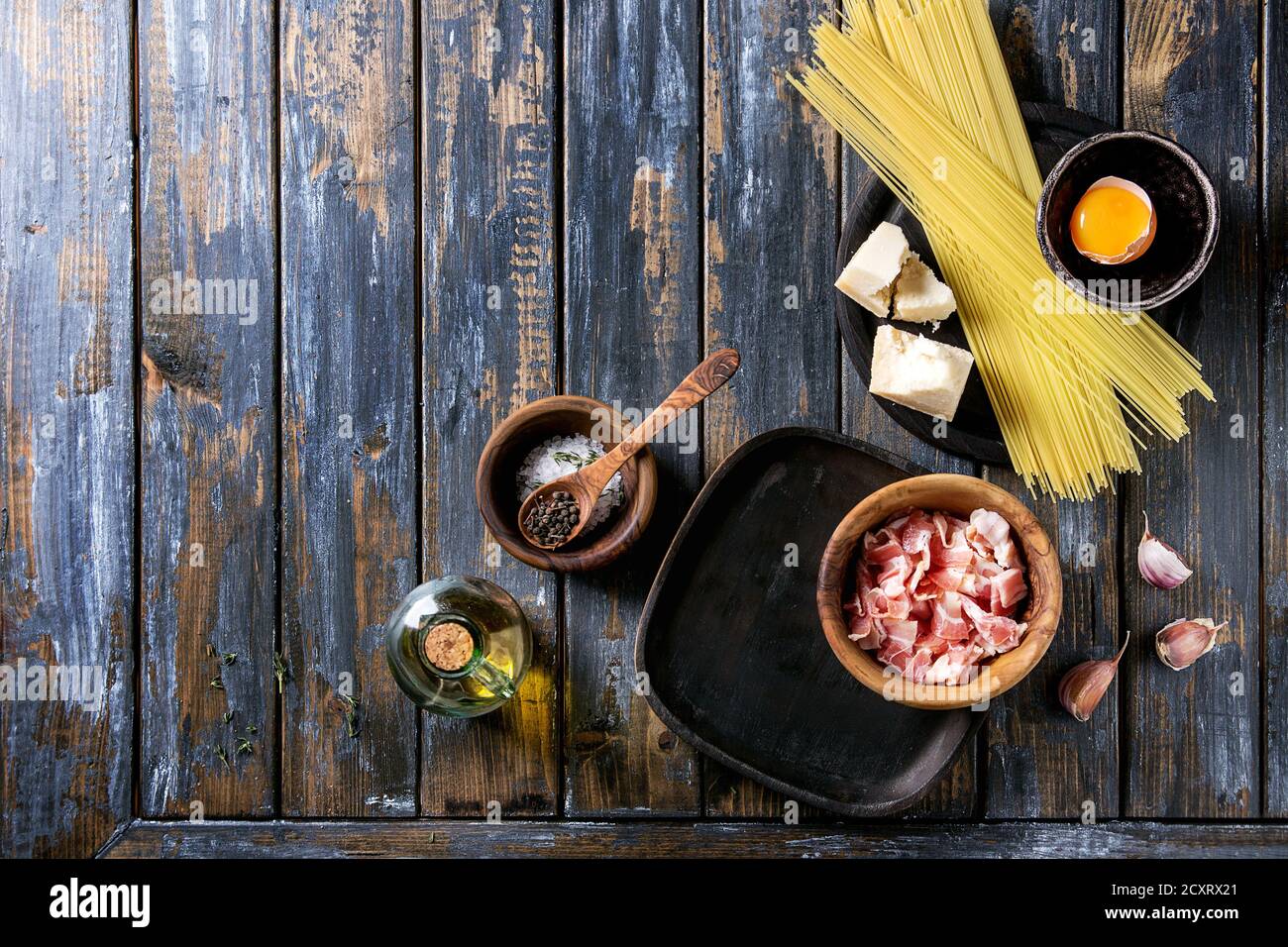 Zutaten für traditionelle italienische Pasta alla Carbonara. Ungekochte Spaghetti, bauchspeck Speck, Parmesan, Eigelb, Salz, Pfeffer in Olivenholz bo Stockfoto