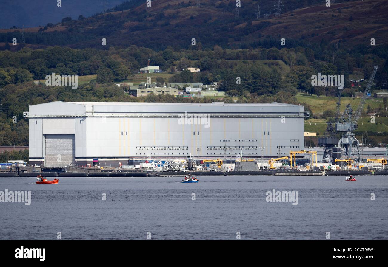 Die Boote fahren gemeinsam an HMNB Clyde in Faslane vorbei, um einen großen Wal vom Gare Loch zu bewegen. Retter von British Divers Marine Life Rescue Medics (BDMLR) nutzen Boote, um eine Schar nördlicher Engpass-Wale aus Loch Long zu holen, weil sie besorgt sind über die möglichen Auswirkungen der Übung Joint Warrior, einer wichtigen internationalen militärischen Übung, die für das Gebiet geplant ist, Da Wale besonders empfindlich auf Unterwassergeräusche reagieren. Stockfoto