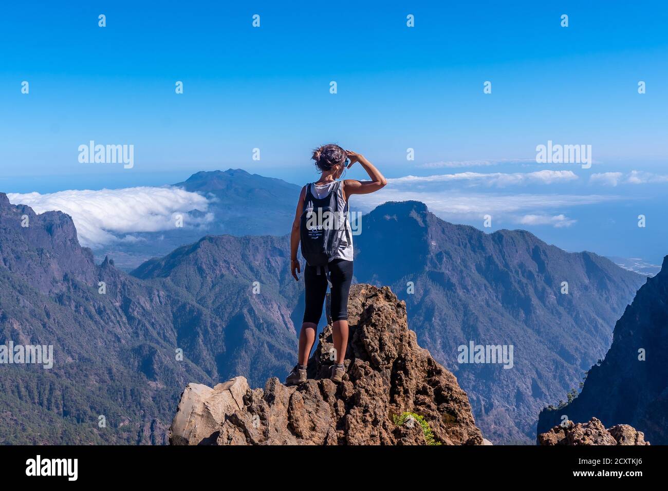 Junge Frau, die vom Gipfel der Caldera aus schaut De Taburiente Vulkan Stockfoto