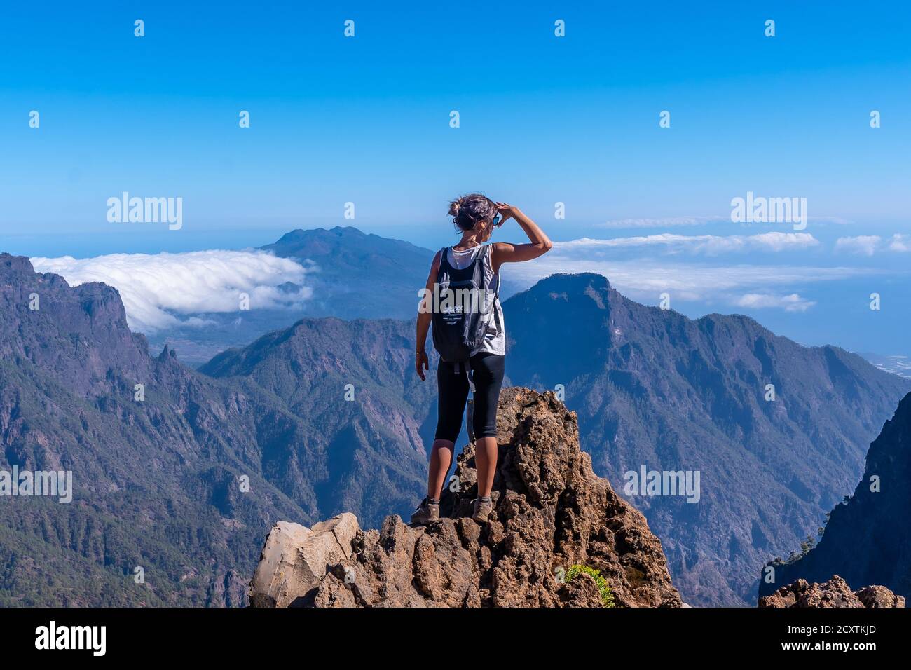 Junge Frau, die vom Gipfel der Caldera aus schaut De Taburiente Vulkan Stockfoto