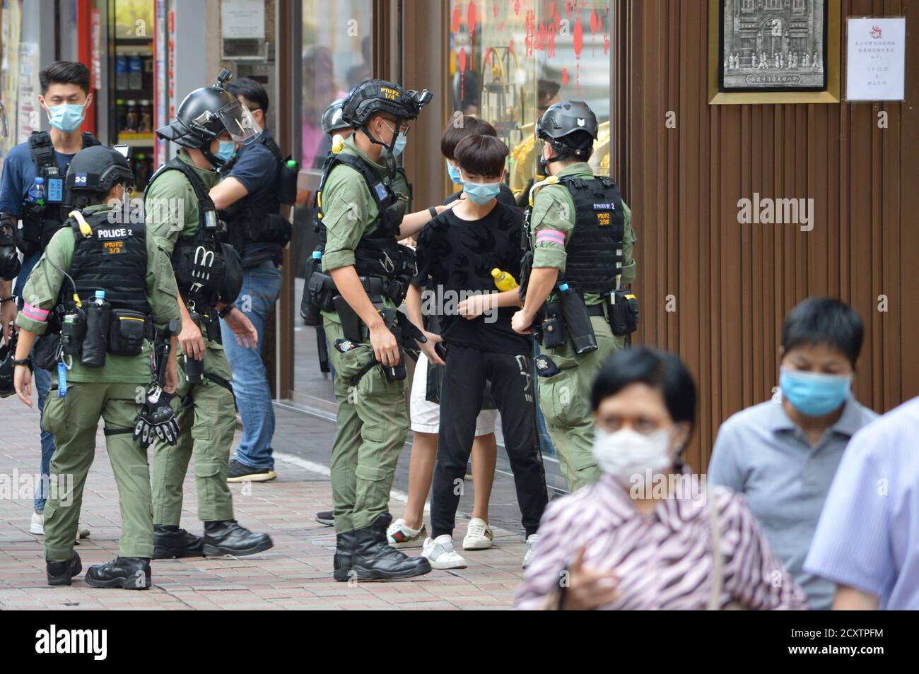 Die Hongkonger Polizei hält an und durchsucht am 1. Oktober 2020 einen jungen Menschen im Einkaufsviertel Causeway Bay Stockfoto