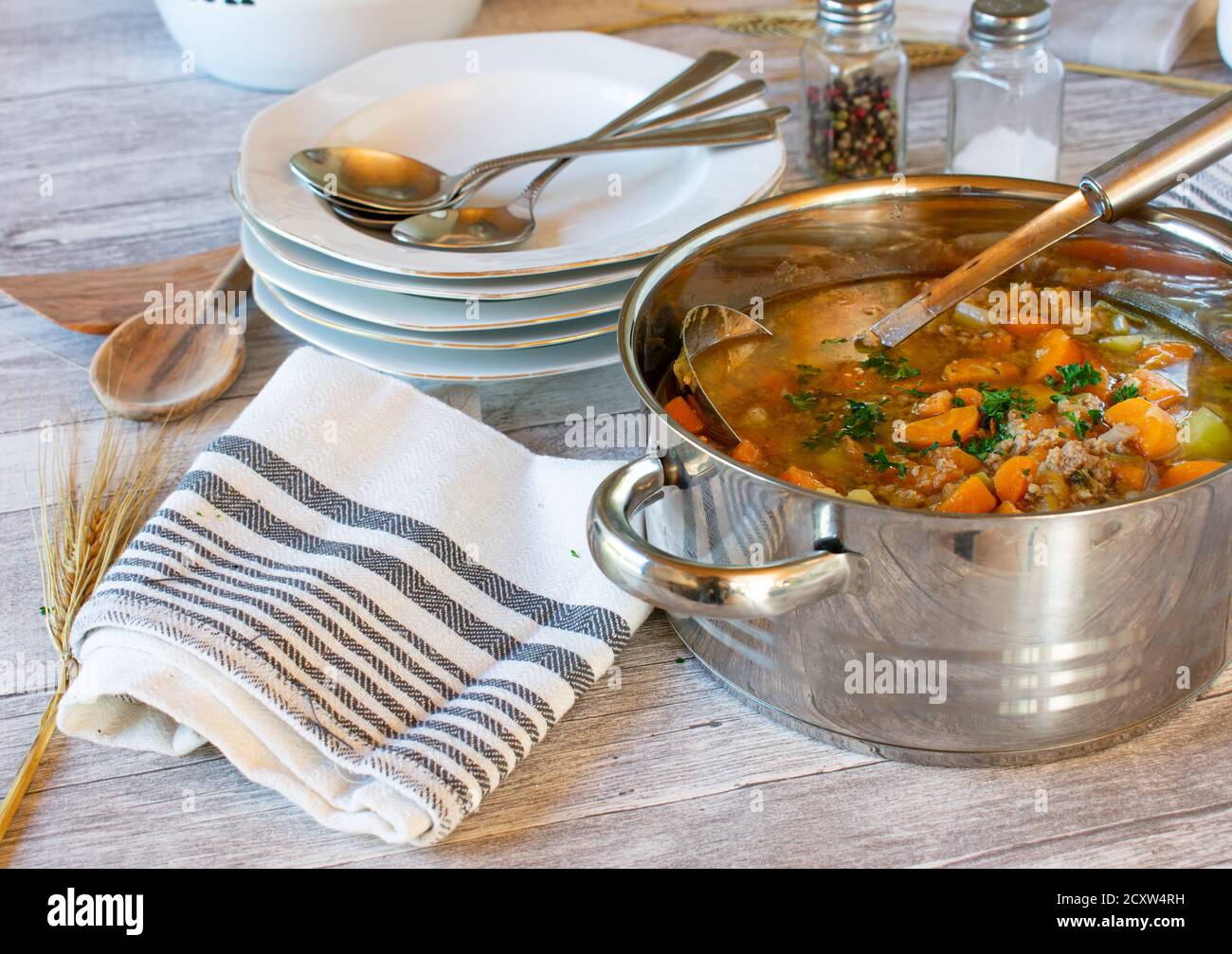 Gemüsesuppe mit Hackfleisch in einem Topf mit Schöpfkelle Auf Holztisch Stockfoto