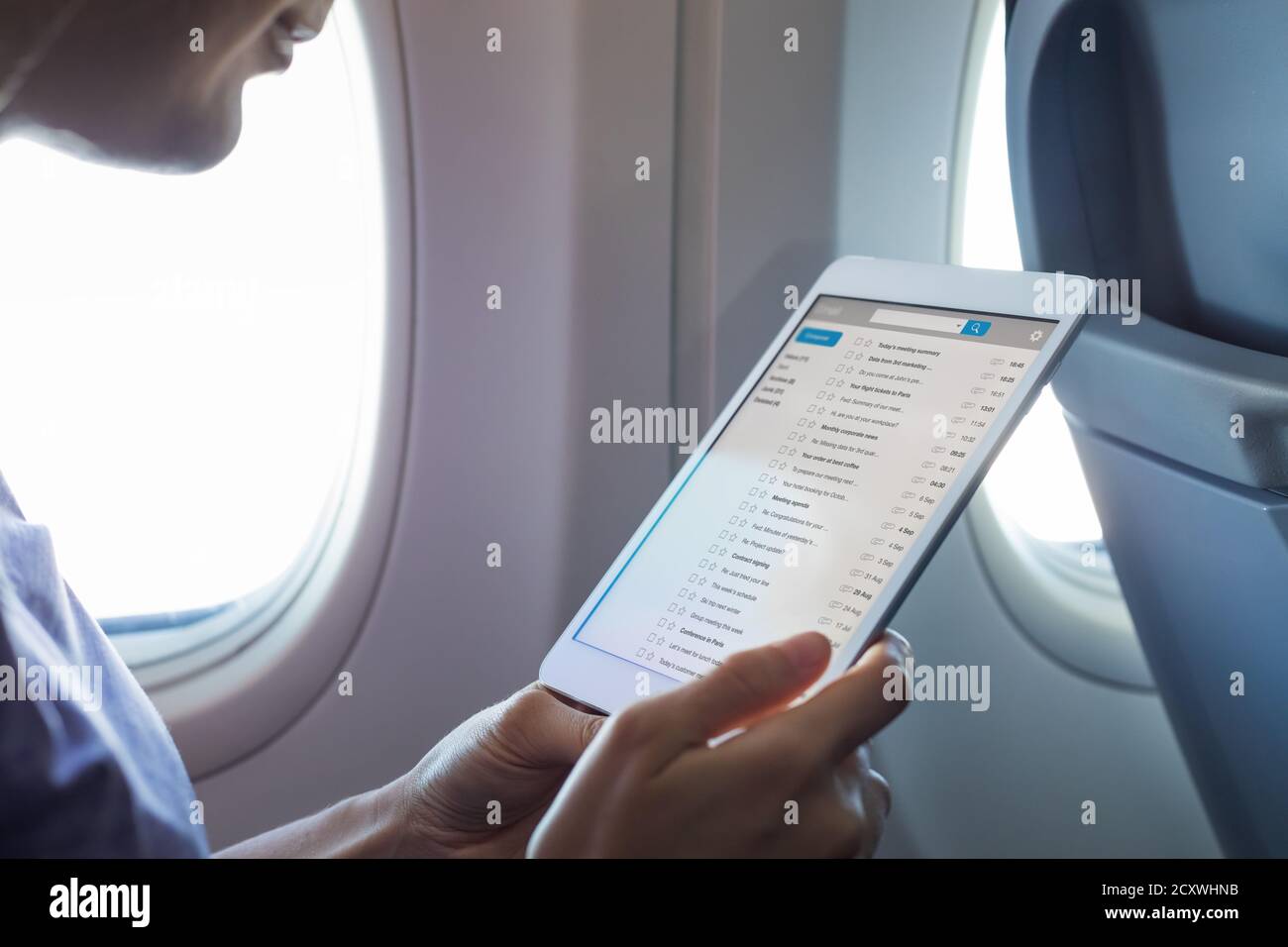 Arbeiten mit E-Mail im Flugzeug während des Fluges mit WiFi-Internetverbindung, Passagier mit Tablet-Computer per E-Mail in Airpla kommunizieren Stockfoto
