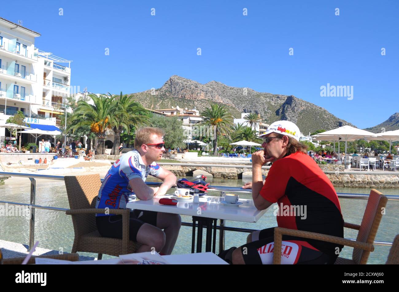 Radfahrer machen eine Pause am Strandcafe Puerto Pollensa Mallorca Stockfoto