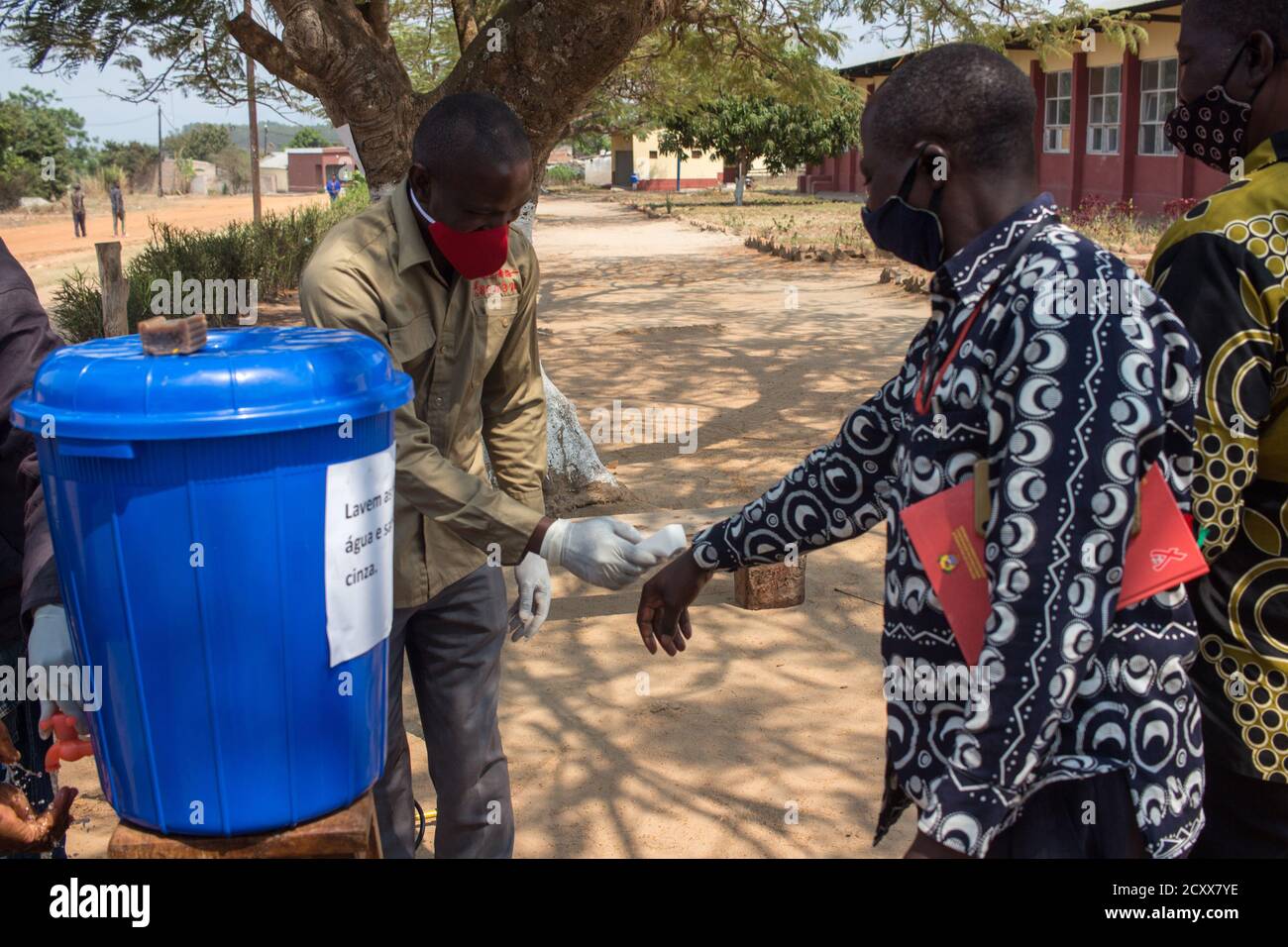 Mann mit Thermometer, um Anzeichen von Coronavirus durch Messung zu erkennen Die Temperatur der Hand der Gäste Stockfoto