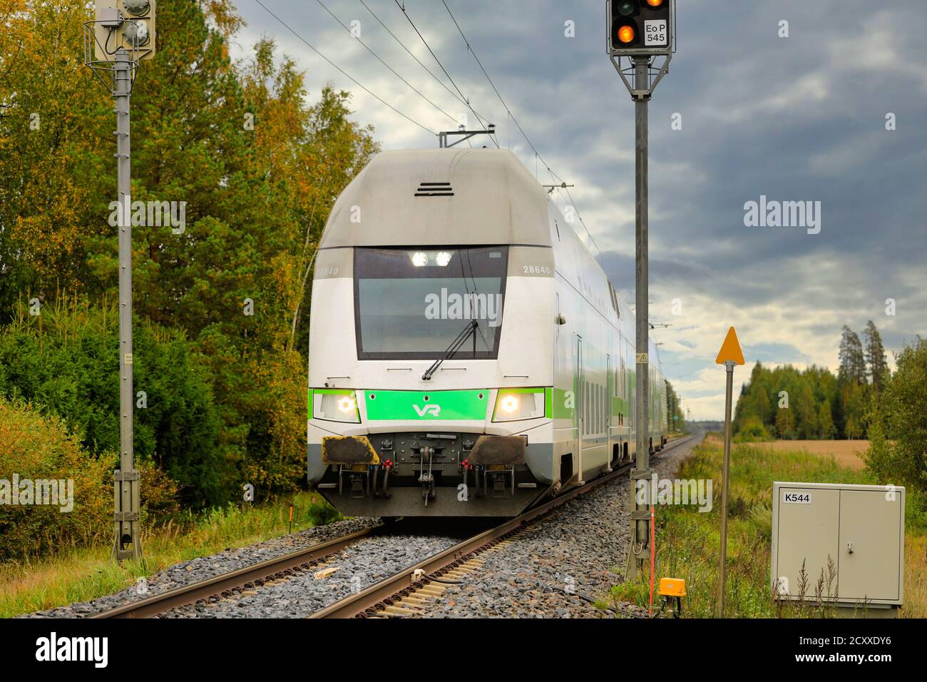 Moderne VR Group Intercity elektrische 2-stöckige Personenzug auf dem Weg an ländlichen Bahnübergang. Loimaa, Finnland. September 18, 2020. Stockfoto