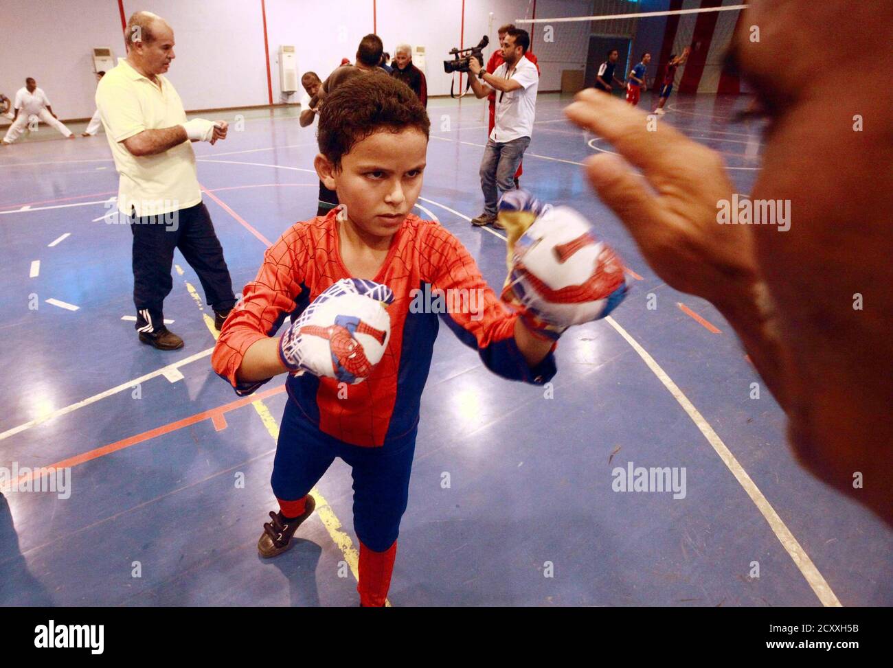 Ahmed, 10, Praktiken Boxen mit Mahmoud im Sportverein in Tripolis 15.  Oktober 2011. Gekleidet in ein Spiderman-Outfit und nur glückliche Schüler  ein paar winzige, misshandelte Boxhandschuhe seines eigenen, war Ahmeds  Vater einer