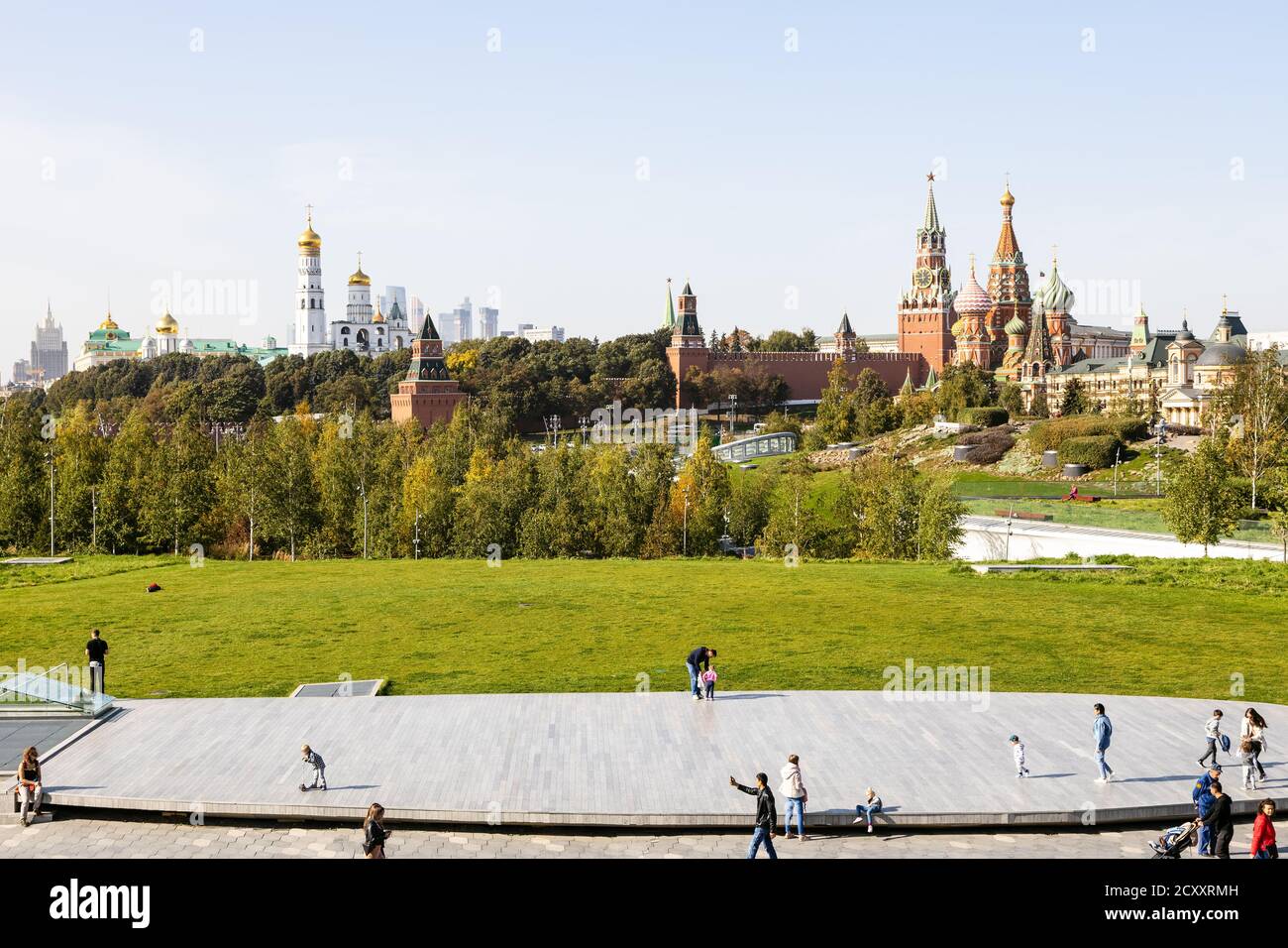 MOSKAU, RUSSLAND - 27. SEPTEMBER 2020: Touristen auf hölzernen Szene des Grand Amphitheatre in Zaryadye Stadtlandschaft öffentlichen Park und Blick auf Kremltürme Stockfoto