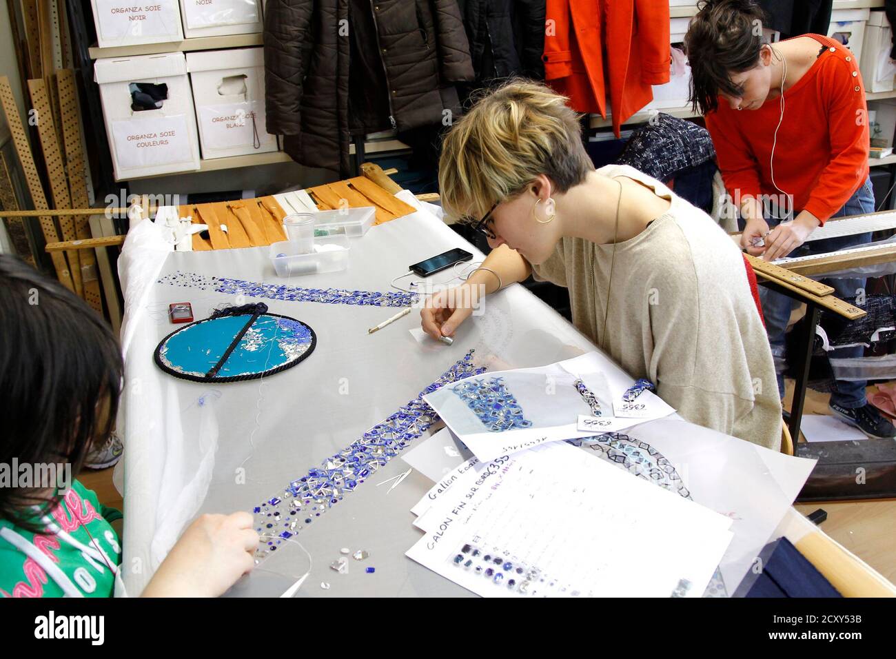 Stickerinnen arbeiten auf einem Chanel Haute Couture-Kleid auf dem  Luxus-Montex-Stickerei-Workshop in Paris 18. Januar 2012. Stickerei Haus  Montex, spezialisiert auf die Erstellung von Stickereien des Hakens  Luneville, die Nadel und die cornely,