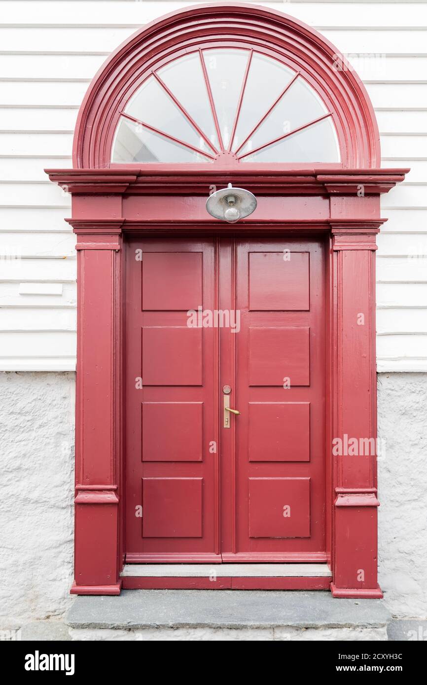 SKUDENESHAVN, NORWEGEN - 2018. JULI 05. Schöne rote Tür mit gebogenem Fenster. Stockfoto