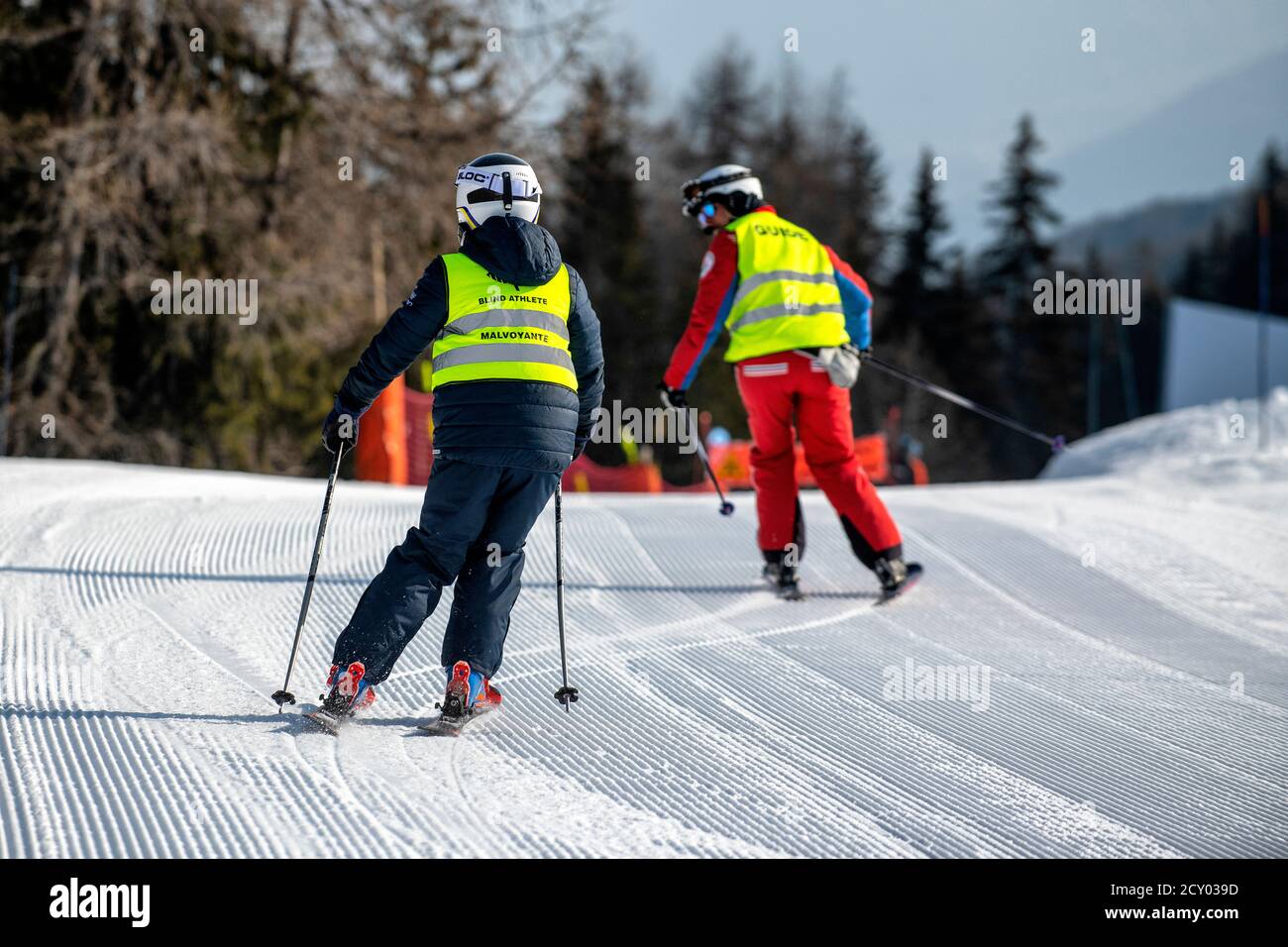 Ein blinder Skifahrer folgt einem Reiseleiter im französischen Skigebiet La Plagne. Sehbehinderung. Stockfoto