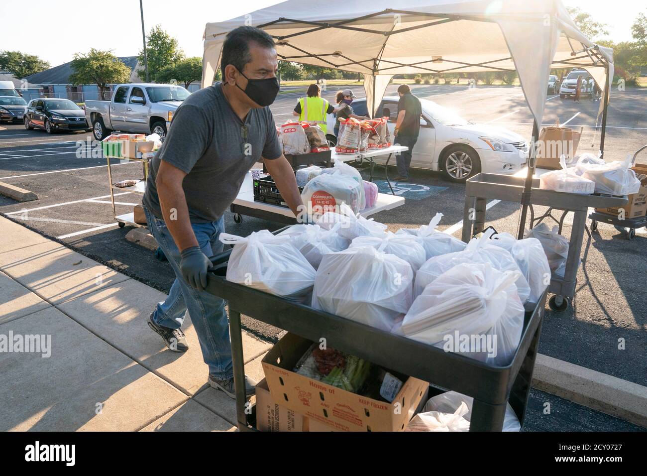 Austin, Texas, USA. Oktober 2020. Mitarbeiter führen zweimal wöchentlich eine Fresh Food-Fahrt durch, die von katholischen Wohltätigkeitsorganisationen unterstützt wird, um einkommensschwachen Texanern zu helfen, in Austin zu einem Treffen zu kommen. Die Bemühungen vom 1. Oktober 2020 halfen mehreren hundert Familienmitgliedern mit Obst, Fleisch, Milch und Getreide. Kredit: Bob Daemmrich/Alamy Live Nachrichten Stockfoto