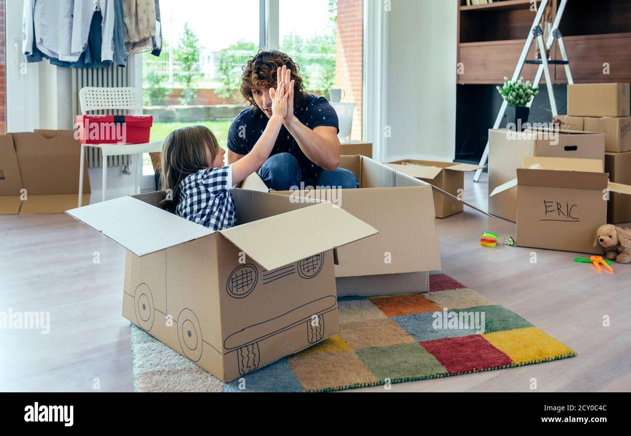 Vater und Sohn geben fünf nach Karton Auto Rennen Stockfoto