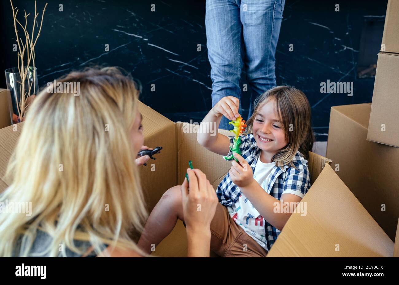 Mutter und Sohn spielen in einer beweglichen Kiste Stockfoto