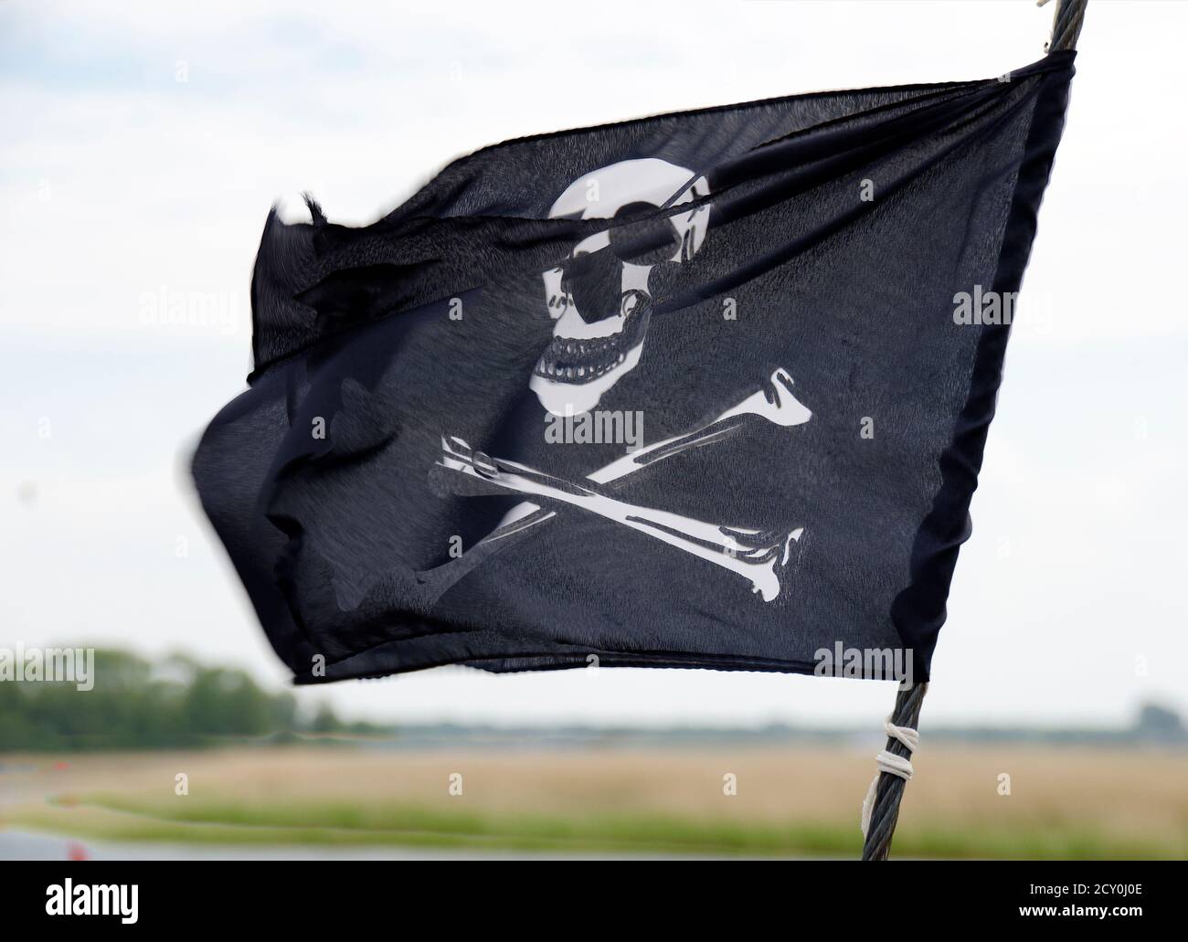 Schwarz-weiße Flagge winkt im Wind mit Totkopf und Gekreuzte Knochen Stockfoto