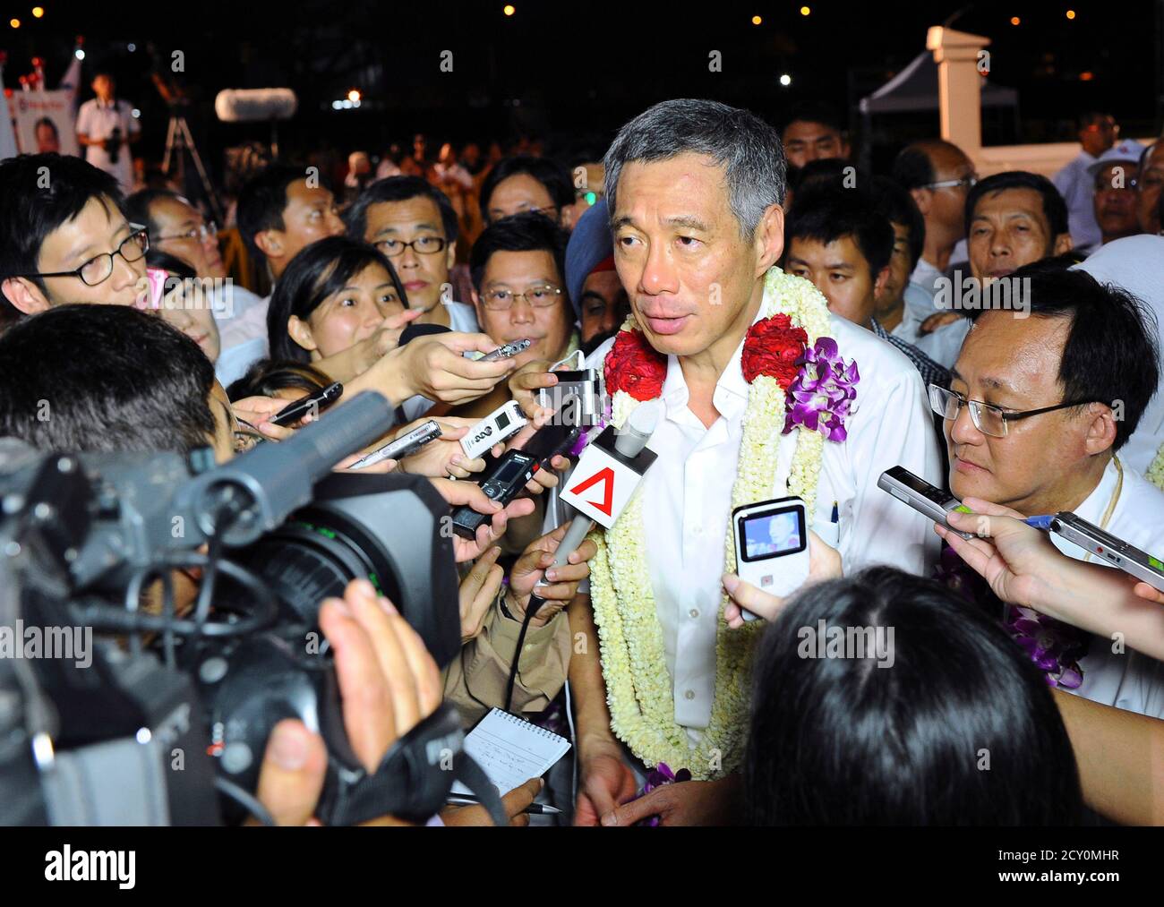 Singapurs Premierminister Lee Hsien Loong spricht neben Seng Han Thong (R), dem Kandidaten der regierenden Volkspartei (PAP), mit den Medien, nachdem er den Repräsentationswahlkreis der Ang Mo Kio-Gruppe (GRC) bei den Parlamentswahlen in Singapur am 8. Mai 2011 gewonnen hatte. REUTERS/Harry Suhartono (SINGAPUR - Tags: POLITISCHE WAHLEN) Stockfoto