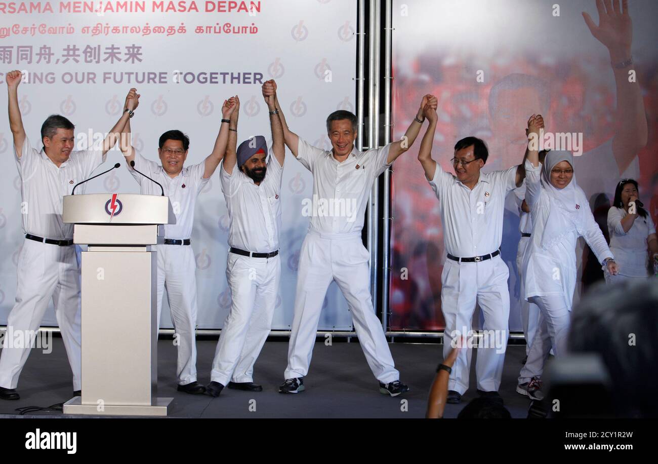 Singapurs Premierminister Lee Hsien Loong (C) feiert mit Kandidaten der regierenden People's Action Party (PAP), nachdem er bei den Parlamentswahlen in Singapur am 8. Mai 2011 den Wahlkreis der Ang Mo Kio-Gruppe (GRC) gewonnen hat. Von links: Ang hin Kee, Yeo guat Kuang, Inderjit Singh, PM Lee, Seng Han Thong und Intan Azura Mokhtar. REUTERS/Edgar Su (SINGAPUR - Tags: POLITISCHE WAHLEN) Stockfoto